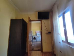 pasillo con puerta a una habitación con lavadora en Edlen, en Tiflis