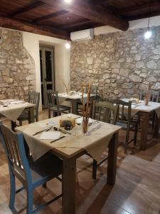 une salle à manger avec des tables et des chaises et un mur en pierre dans l'établissement Tenuta del Savonisco, à Picinisco