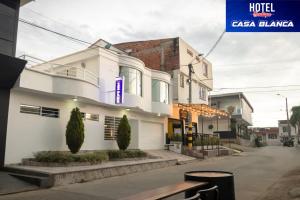 a white building with a purple sign on it at Hotel Boutique Casa Blanca Zarzal in Zarzal
