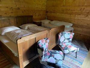 a room with four bunk beds and two chairs at Grawandhütte in Ginzling