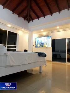 a room with a bed and a flat screen tv at Hotel Boutique Casa Blanca Zarzal in Zarzal