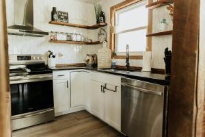 a kitchen with white cabinets and stainless steel appliances at NO CHORES Cozy Family Cabin 2 minutes to town-Spacious Double Decks with Forest view! in Nashville
