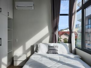 a bedroom with a bed and a large window at An Home - Phòng đơn ngay bãi sau Vũng Tàu in Vung Tau