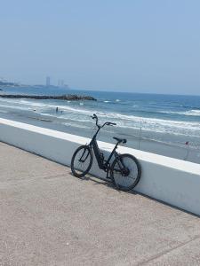 ein Fahrrad, das neben einer Mauer am Strand geparkt ist in der Unterkunft HOTEL INTI in Boca del Río