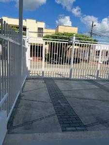 um portão branco em frente a um edifício em Lujoso apartamento central em Montería