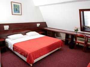 Motel Plitvice Zagreb في زغرب: غرفة نوم بسرير كبير مع بطانية حمراء