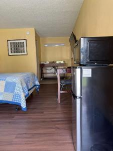 a small room with a refrigerator and a bed at DELUXE INN in Warsaw