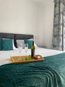 uma bandeja com uma garrafa de vinho e dois copos numa cama em Jolie Ann Marie apartment em Kaštela