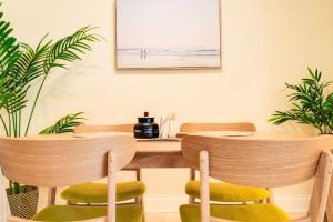 un comedor con 2 mesas y sillas verdes en Intracoastal Oasis in a Prime Area w Pool and BBQ, en Fort Lauderdale