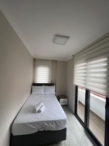 um quarto com uma cama e duas janelas em Albayrak apart em Pelitli