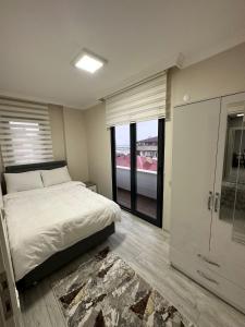 um quarto com uma cama e uma grande janela em Albayrak apart em Pelitli