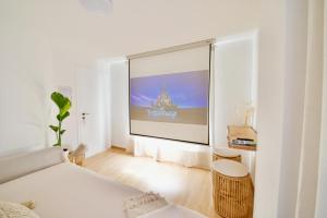 Habitación blanca con una gran pantalla en la pared en Boho Lake House - Private Beach 600m from the property - Free Parking - Home Cinema Room en Vira