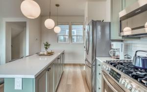 a kitchen with green cabinets and a stove top oven at Organic by Nature in Depoe Bay