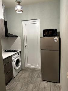 een keuken met een koelkast en een wasmachine bij BEST VIEW OF KUTAISI in Koetaisi