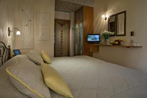 ein Schlafzimmer mit einem großen weißen Bett und gelben Kissen in der Unterkunft Ionas Boutique Hotel in Chania