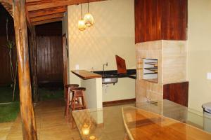 a kitchen with a glass table and a counter at Chalé Ubá in Novo Airão