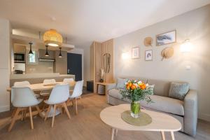 a living room with a couch and a table at Clapotis des Flots St Tropez XII in Saint-Tropez