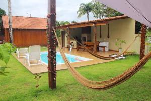 a hammock in front of a house with a pool at Chalé Ubá in Novo Airão