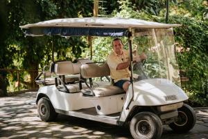 a man is sitting in a golf cart at Parador Nature Resort and Spa in Manuel Antonio