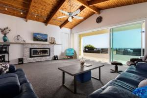 a living room with a couch and a fireplace at Pats Place on the Beach in Papamoa