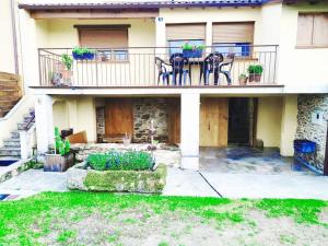 a house with a balcony with a table and chairs at Casa das Pozas in Distriz