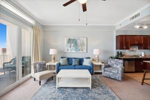 - un salon avec un canapé bleu et des chaises dans l'établissement Laketown Wharf #2119 by Nautical Properties, à Panama City Beach