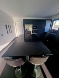 a kitchen with a black table and two chairs at Villa Sunset in Guia