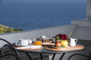 a table with a breakfast of fruit and juice at Il Gelso Vacanze in Malfa