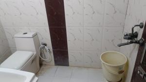 a bathroom with a toilet and a bucket in it at Blossom residency By Dolphin 500 Mtr Taj mahal in Agra