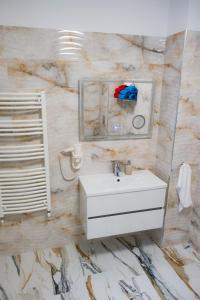 W łazience znajduje się umywalka i lustro. w obiekcie EDA ROOMS w Sybinie