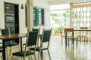 un comedor con mesas y sillas y una ventana en Hostal Backpackers Travelero en Santa Cruz de la Sierra