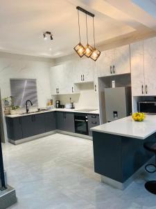 a large kitchen with a sink and a counter top at modern, two-story luxury house in Gaborone