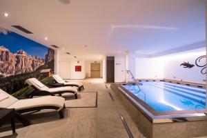 una piscina en una sala de estar con una pintura en la pared en Golden Park Resort en Campitello di Fassa