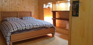 a bedroom with a bed in a log cabin at Le chalet des nounours in Boutx