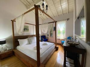 ein Schlafzimmer mit einem Himmelbett und einem Schreibtisch in der Unterkunft Nisi Hotel in Ayvalık
