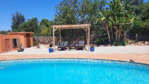uma piscina com um gazebo e um baloiço em Rural Peace in the Algarve - Private Room with kitchenette and bathroom em Aldeia dos Matos