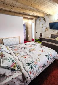 a bedroom with a bed with a floral comforter at Casa Danci II in Borşa