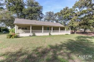 a small house with a porch on a field at Retreat to the Outdoors with Colorado River Access in Austin