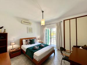 um quarto com uma cama, uma cadeira e uma janela em Tavira Palm Tree by Homing em Tavira
