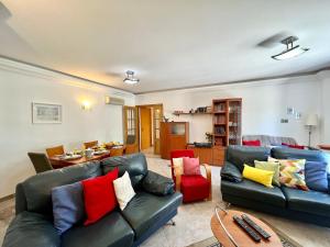 uma sala de estar com dois sofás de couro e uma mesa em Tavira Palm Tree by Homing em Tavira