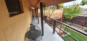 a balcony with a table and chairs and a television at Pensiunea Casa Beatrice in 2 Mai