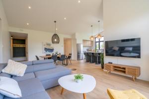 a living room with a blue couch and a table at Halte 4 Saisons- en nature à 5 min du Mont-Orford! in Orford