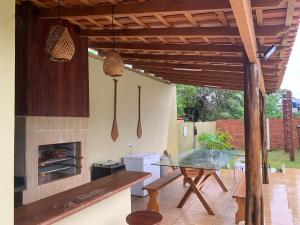 a kitchen with a glass table and a fireplace at Chalé Ubá in Novo Airão