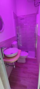 een roze badkamer met een toilet en een wastafel bij L'Incanto del Borgo Antico- Locazione Turistica in Bari