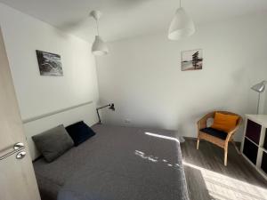 a small bedroom with a bed and a chair at Sirály apartman in Keszthely