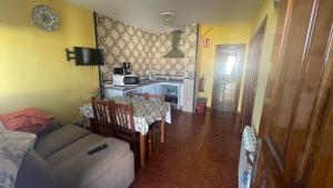 a living room with a table and a couch and a kitchen at ELROSAL2 in Cudillero