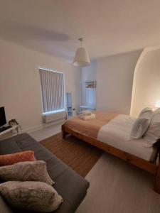 a bedroom with a large bed and a couch at Cosy modern house in Liverpool
