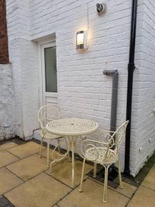 una mesa y dos sillas sentadas junto a un edificio en Cosy modern house, en Liverpool