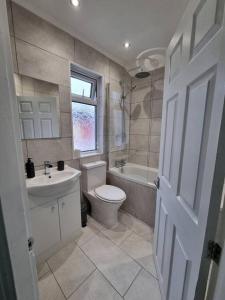 łazienka z toaletą, umywalką i wanną w obiekcie Cosy modern house w Liverpoolu