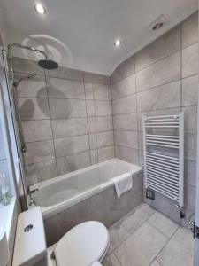 a bathroom with a toilet and a bath tub at Cosy modern house in Liverpool